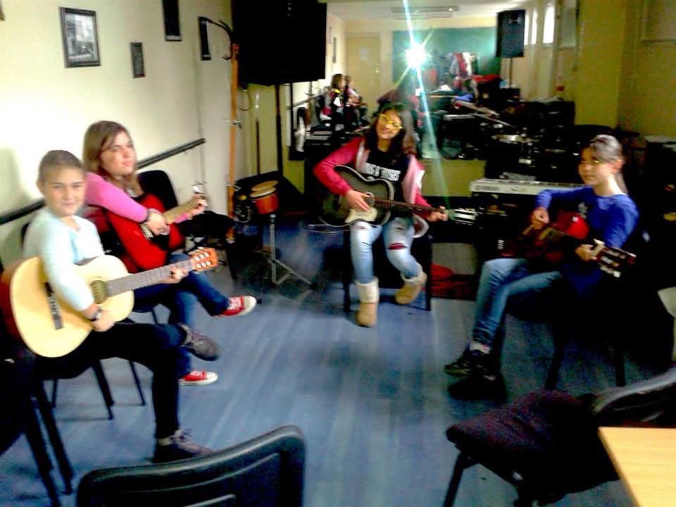 Polaznici sviraju gitare u krugu na grupnoj radionici na Banovom brdu